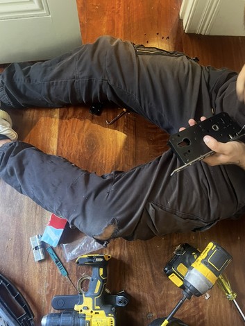 Locksmith repairing a mortice lock body on-site in a home